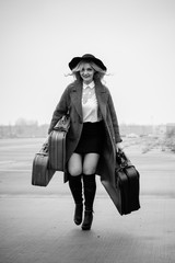 Fototapeta na wymiar Retro style picture of an traveler with suitcase in the airport, girl in retro style with vintage suitcase 