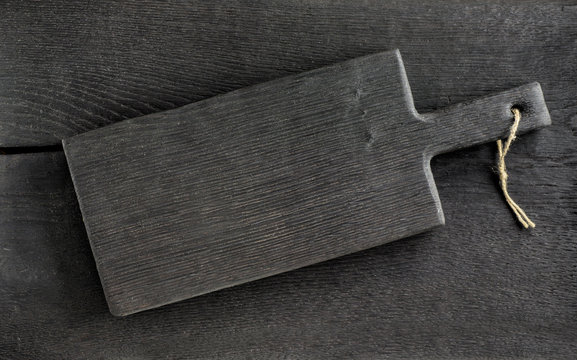 black cutting board on wooden table