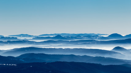 A frozen morning on top of Ciucas mountains in Romania with some beautiful clouds dancing in the valley bellow