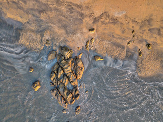 Top view of stones on a sandy beach