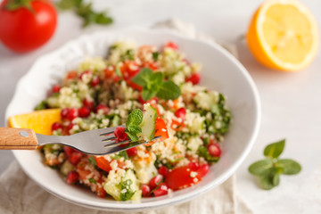 Tabbouleh salad with tomato, cucumber, couscous, mint and pomegranate. Vegan Healthy Food Concept. Traditional middle eastern or arab dish.