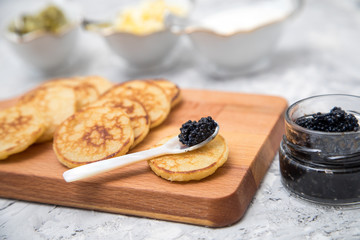Schwarzer Kaviar auf Perlmuttlöffel mit Pfannkuchen, Eier Hack, Saure Sahne und Relish 