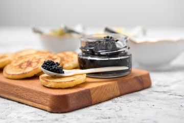 Deutscher Kaviar auf Perlmutt Löffel mit Blinis, gehackte Eier, Saure Sahne und Gurkenrelish