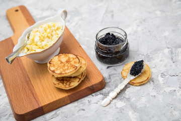 Schwarzer, deutscher Kaviar mit Blinis und Eier Hack auf Holzbrett