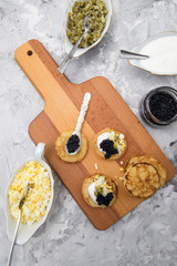 Deutscher Kaviar auf Perlmutt Löffel mit Blinis, gehackte Eier, Saure Sahne und Gurkenrelish