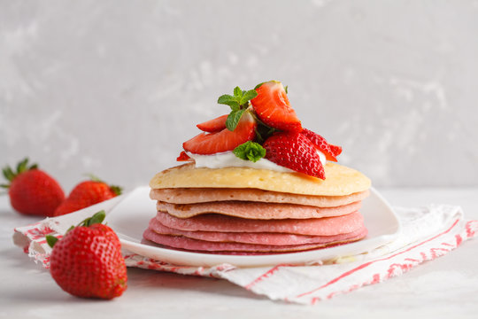 Stack of pink ombre  pancakes with strawberries and cottege cream. Breakfast background, copy space.