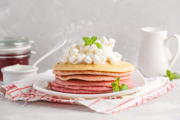 Fototapeta na wymiar Stack of pink ombre pancakes with marshmallow and strawberries. Breakfast background, copy space.