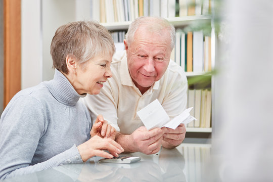 Paar Senioren mit Taschenrechner und Kassenzettel