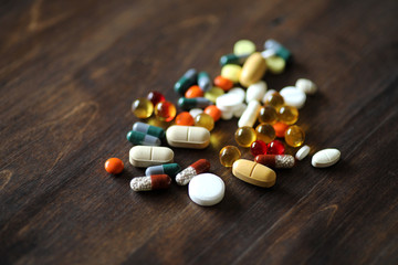 Medications and tablets on a wooden texture table