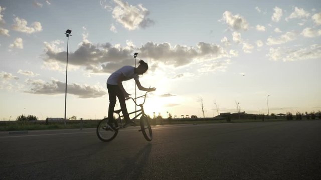 Slow motion of hipster young man losing control of bike failing jump trick