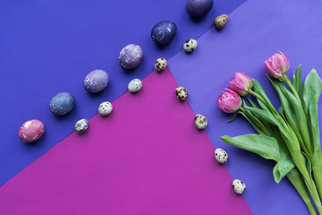 flat lay with painted eggs and tulips on background in purple tones