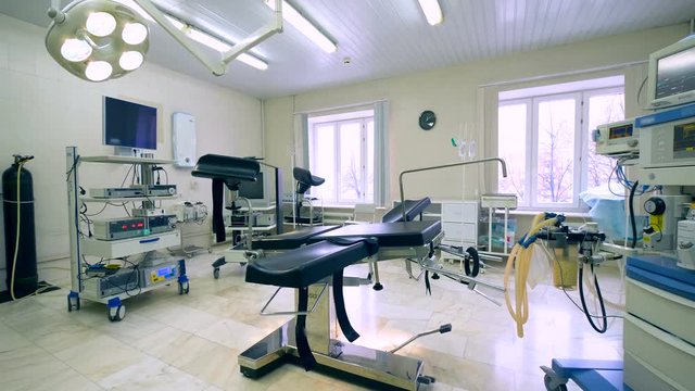 Wide angle view of a hospital gynecological room with an examination chair in it