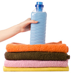 A stack of towels liquid powder conditioner softener in hand