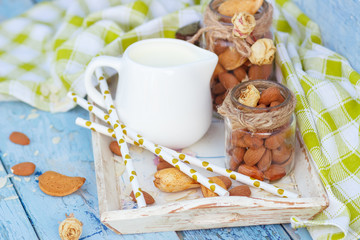 Almonds and jar with milk on the wooden tray