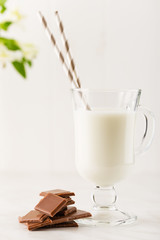 Milk chocolate with glass of milk on white background