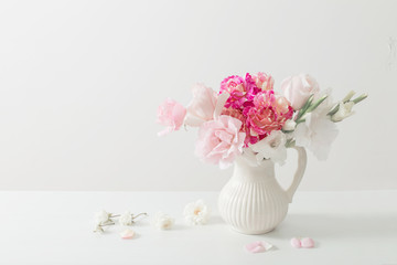 pink and white flowers in vase on white background