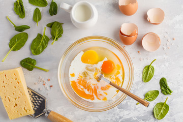 Raw ingredients for omelette with cheese and spinach. Breakfast concept, top view, copy space.