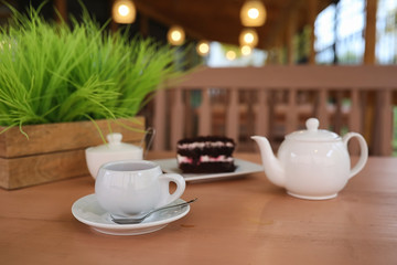 Kettle with a drink and dessert in a street cafe. Tea in the ket