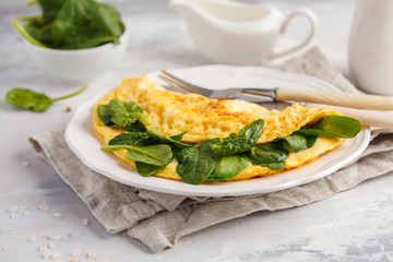 Omelette stuffed with spinach and cheese for a breakfast. Breakfast concept.
