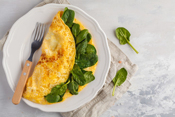 Omelette stuffed with spinach and cheese for a breakfast, top view. Breakfast concept.