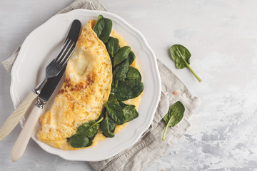 Omelette stuffed with spinach and cheese for a breakfast, top view. Breakfast concept.