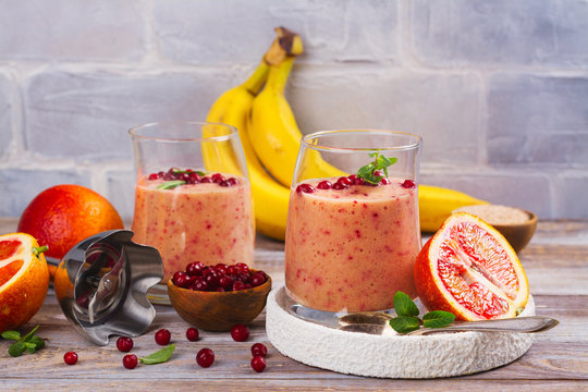 Healthy refreshing pink smoothie with apple, red oranges, cowberry and bran