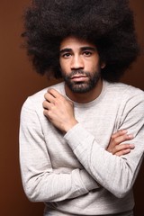 Afro man in front of a brown background