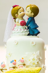 Fototapeta na wymiar Topping sweet wedding cake./ Topping wedding couple doll on wedding cake decoration. 