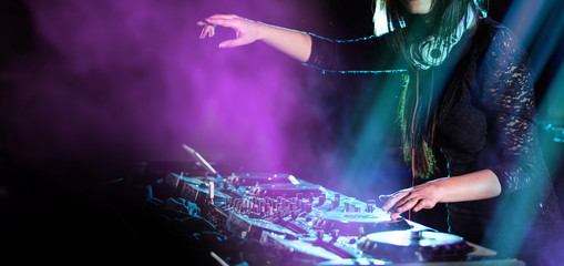 Dj mixes the track in the nightclub at a party