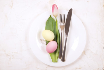 Easter laying table appointments, table setting options. Silverware, tableware items with festive decoration. Fork, knife and flowers. Happy easter holiday.