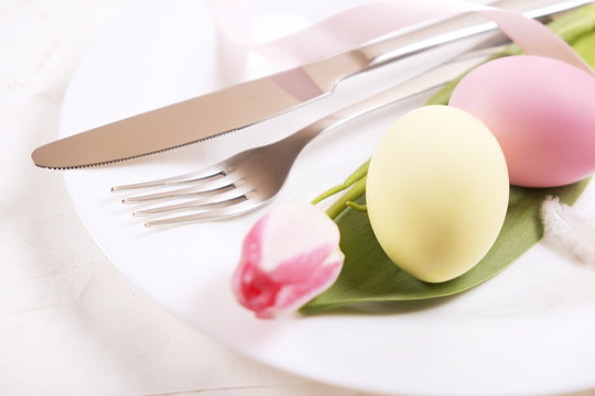 Easter laying table appointments, table setting options. Silverware, tableware items with festive decoration. Fork, knife and flowers. Happy easter holiday.