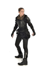 full length portrait of female  soldier wearing black  tactical armour, isolated on white studio background.