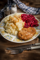 Pork cutlet with minced meat served with boiled potatoes and beetroot.