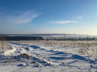 snow-covered grass on the field in a sunny afternoon in frost