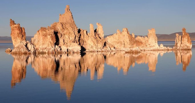 Mono lake tufas with reflection in calm water close-up on sunrise.