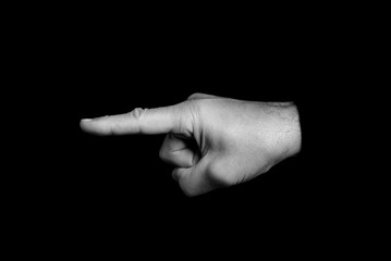 pointing finger - hand gestures on a black background - black and white photo