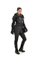 full length portrait of female  soldier wearing black  tactical armour, isolated on white studio background.