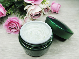 Fototapeta na wymiar cosmetic cream for face care and rose flowers