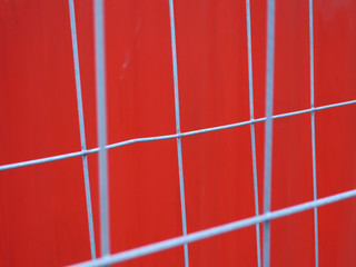 Fence in front of red container