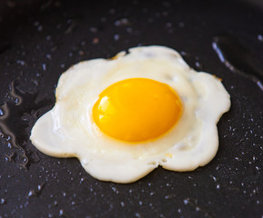 Tasty beautiful food fried egg in the black pan.