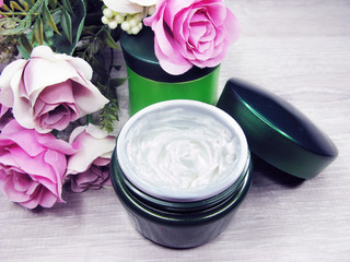 Obraz na płótnie Canvas cosmetic cream for face care and rose flowers
