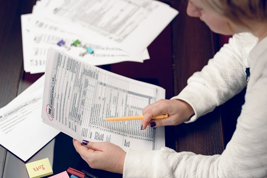 Woman fills the tax form, working with tax documents.Form 1040 Individual Income Tax return form. United States Tax forms 2017/2018.