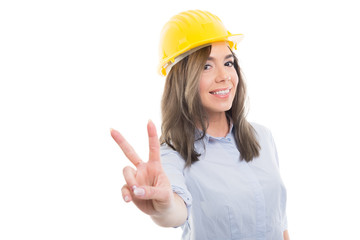 Portrait of female constructor showing peace gesture.