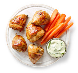 grilled chicken legs on wooden cutting board