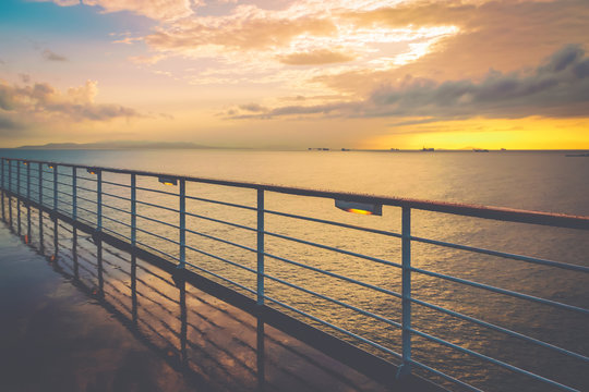 Cruise ship railing at sunset after a rainy day.