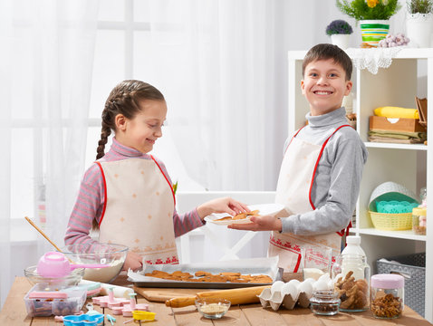 Boy and girl with a homemade baked cookies, home kitchen interior, healthy food concept