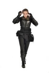 full length portrait of female  soldier wearing black  tactical armour, isolated on white studio background.