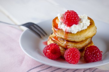 Pancakes with custard and raspberries