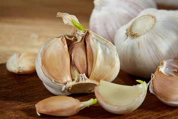 Garlic close up on wooden plate on rustic background, shallow depth of field, selective focus, macro