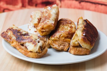 Rolled french toasts on white plate